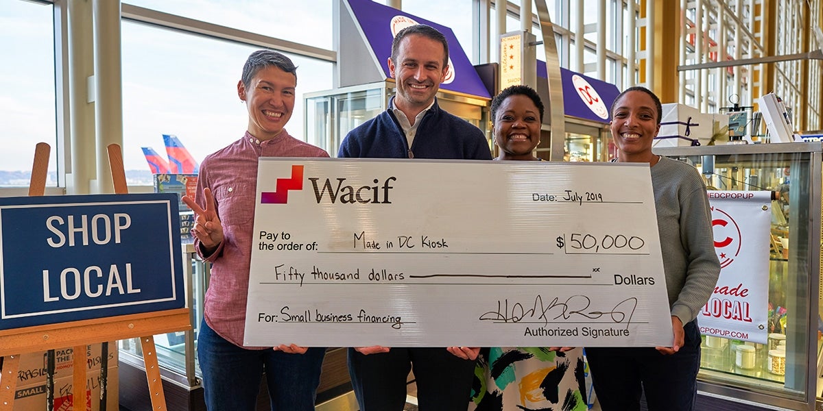 Photograph of people with a large-size donation check